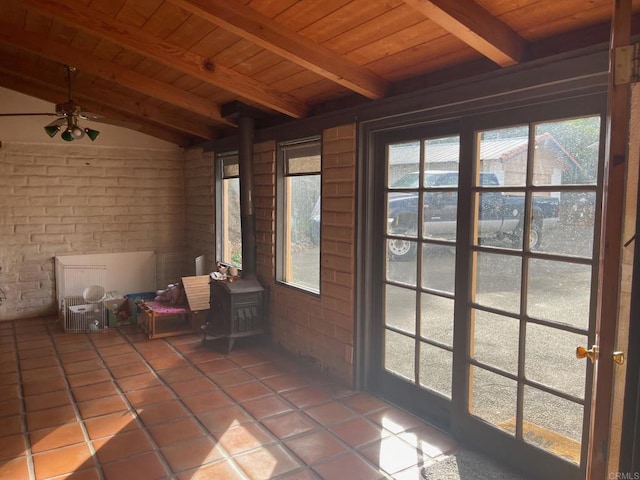 unfurnished sunroom featuring lofted ceiling with beams, wooden ceiling, and a wood stove