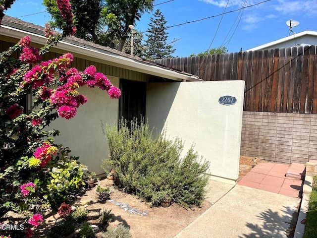 view of property exterior featuring fence and stucco siding