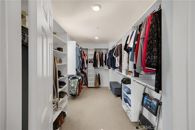 walk in closet with light colored carpet