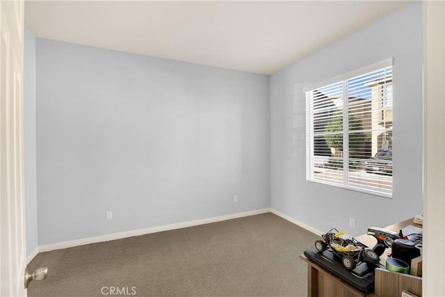 empty room featuring carpet flooring and baseboards