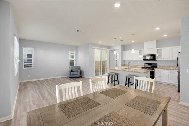 dining area with light wood finished floors, baseboards, and recessed lighting