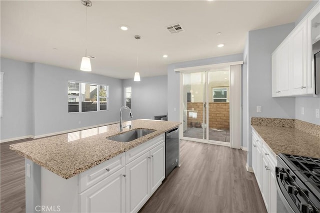 kitchen featuring visible vents, white cabinetry, a sink, wood finished floors, and dishwasher