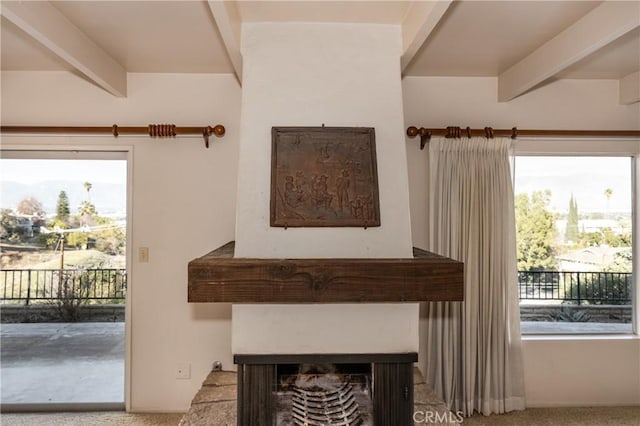 details with carpet, beam ceiling, and a multi sided fireplace