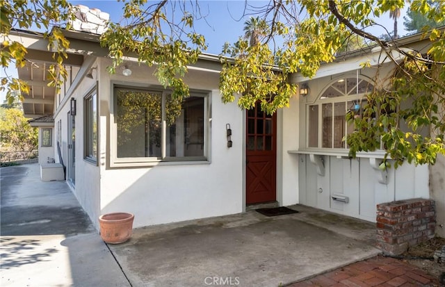 entrance to property featuring stucco siding