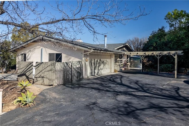 view of home's exterior with a garage, driveway, and stucco siding