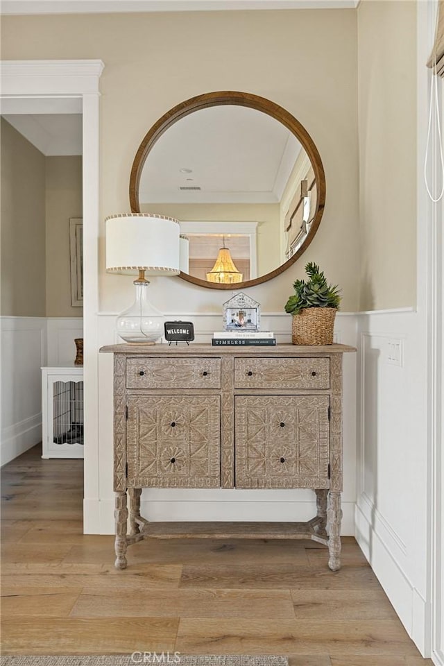 interior space with a wainscoted wall, a decorative wall, wood finished floors, and vanity