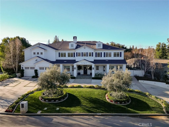 shingle-style home with a front lawn, concrete driveway, and an attached garage