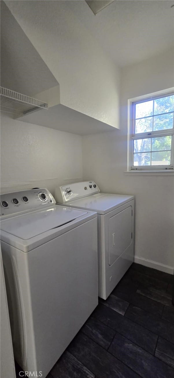 laundry room with laundry area, dark wood finished floors, washer and clothes dryer, and baseboards