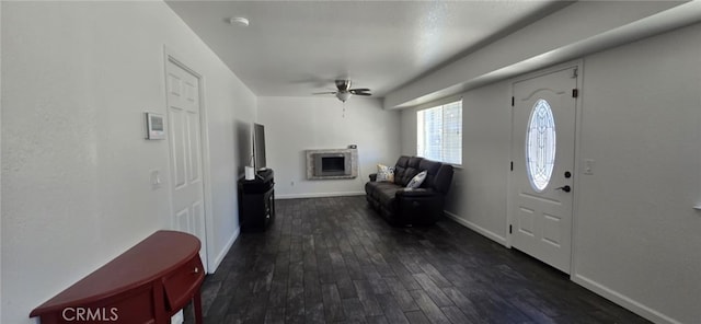 entryway with dark wood-style flooring, a fireplace, baseboards, and ceiling fan