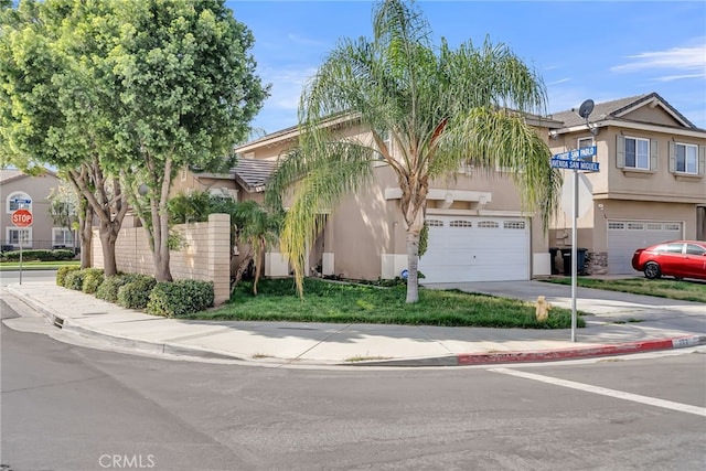 townhome / multi-family property featuring an attached garage, concrete driveway, and stucco siding