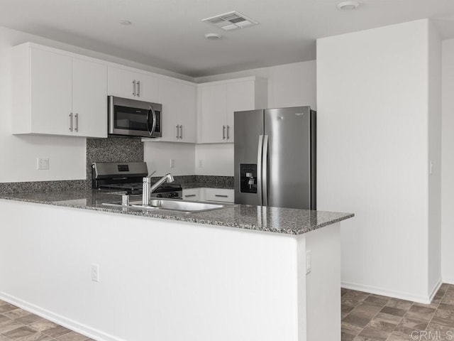 5106 Belle Way, Hemet, CA 92545 - kitchen with visible vents, dark stone counters, appliances with stainless steel finishes, a peninsula, and a sink