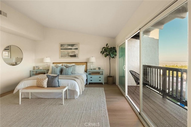 bedroom featuring lofted ceiling, visible vents, and wood finished floors