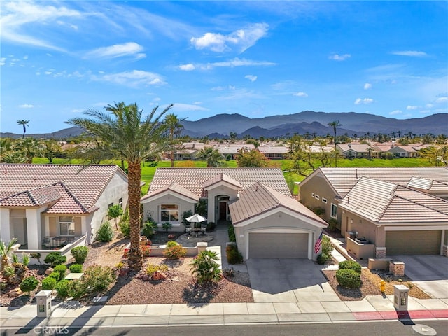 mediterranean / spanish-style house with driveway, a residential view, and a mountain view