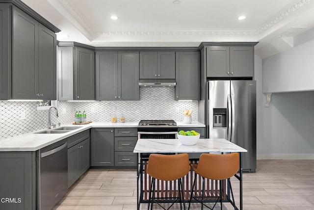 kitchen featuring stainless steel appliances, wood tiled floor, a sink, and backsplash