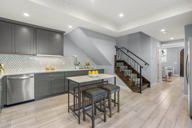 kitchen featuring tasteful backsplash, arched walkways, dishwasher, and wood finish floors