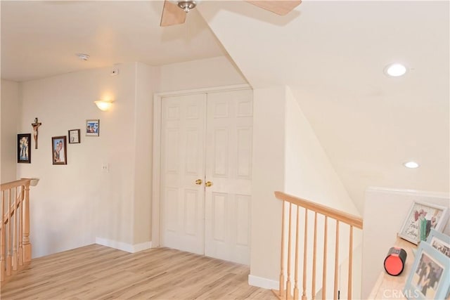 hall with recessed lighting, baseboards, an upstairs landing, and wood finished floors