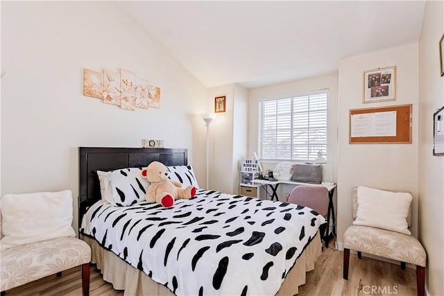 bedroom featuring light wood-style floors and vaulted ceiling