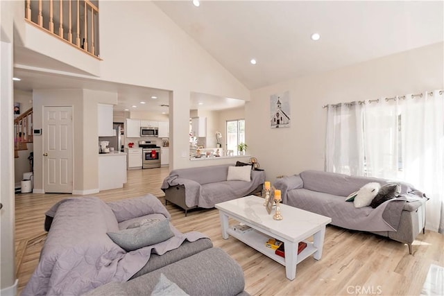 living room featuring baseboards, stairway, light wood-type flooring, high vaulted ceiling, and recessed lighting