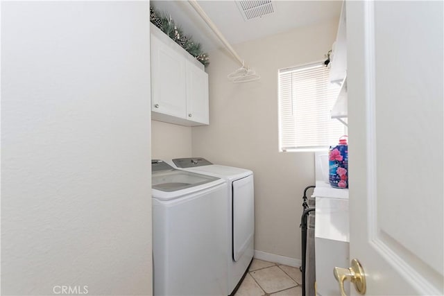 clothes washing area featuring light tile patterned floors, cabinet space, visible vents, washing machine and dryer, and baseboards