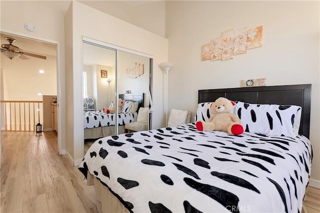 bedroom featuring light wood finished floors, baseboards, and a closet