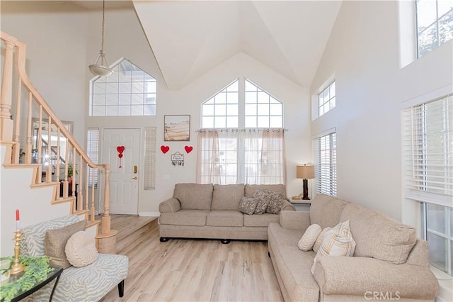 living room featuring stairs, high vaulted ceiling, and wood finished floors