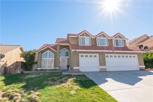 view of front of house featuring concrete driveway, a front yard, fence, a garage, and a tiled roof