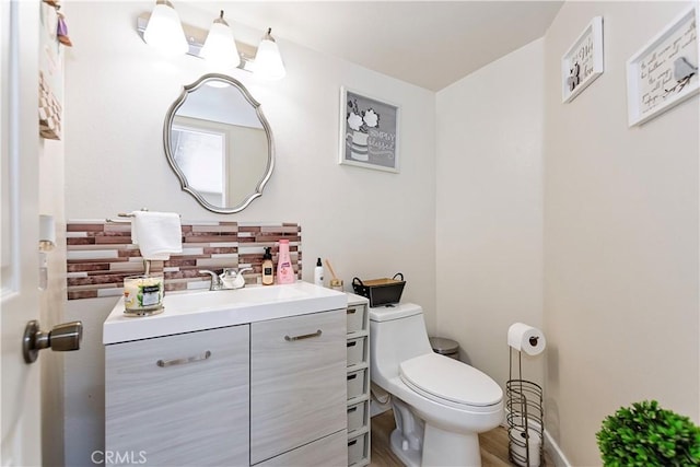 bathroom featuring toilet, tasteful backsplash, and vanity