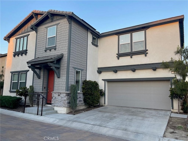 view of front of home with a garage, stone siding, concrete driveway, and stucco siding