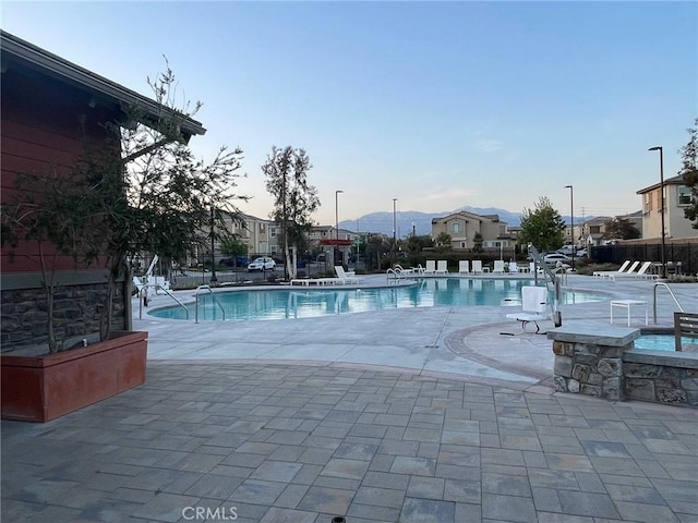 community pool featuring fence and a patio