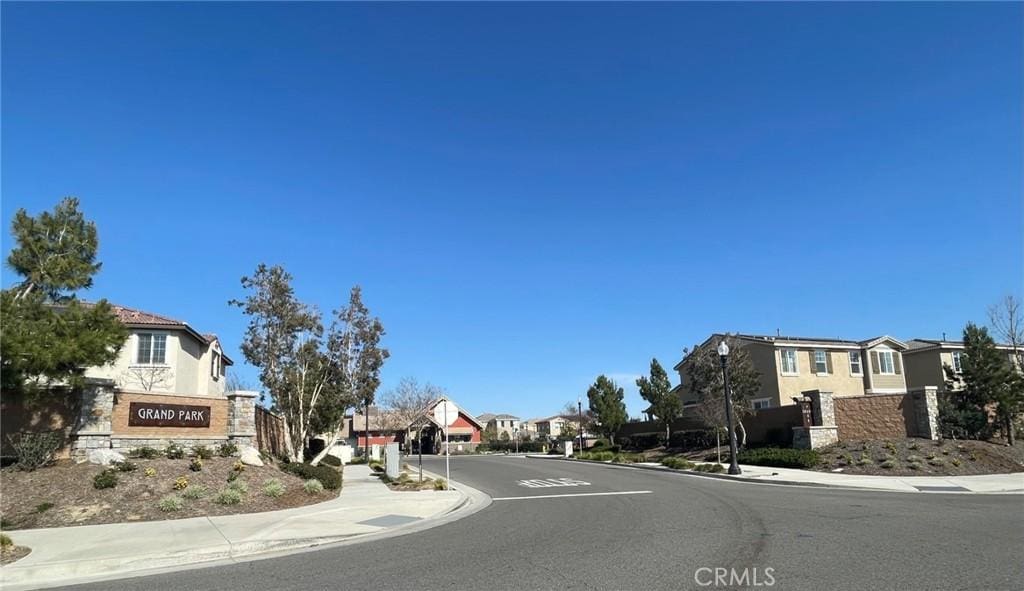 view of road with sidewalks, street lighting, a residential view, and curbs