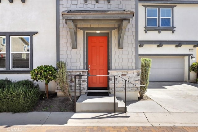 3235 E Yellowstone Dr, Ontario, CA 91762 - property entrance featuring driveway, stucco siding, a garage, and stone siding