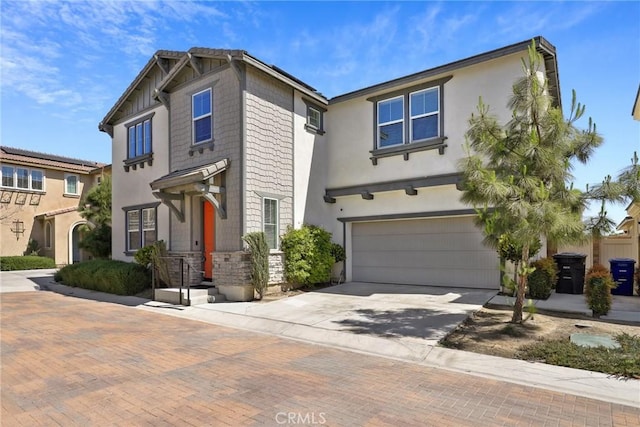 3235 E Yellowstone Dr, Ontario, CA 91762 - view of front of home featuring stone siding, stucco siding, driveway, and a garage