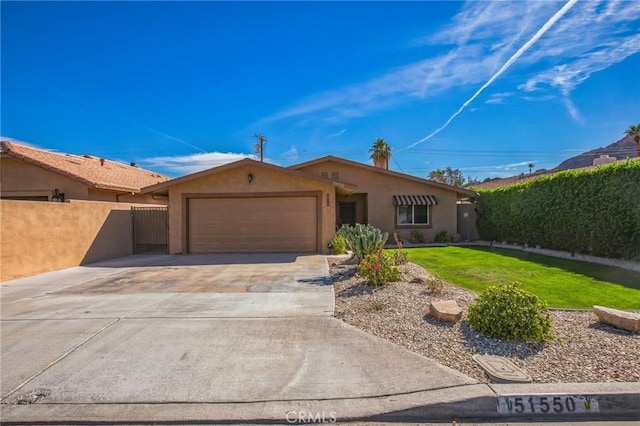 single story home with a garage, driveway, fence, and stucco siding