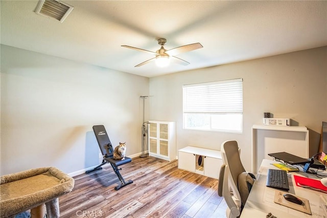 office with ceiling fan, wood finished floors, visible vents, and baseboards