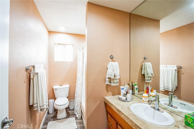 bathroom with a shower with shower curtain, vanity, and toilet