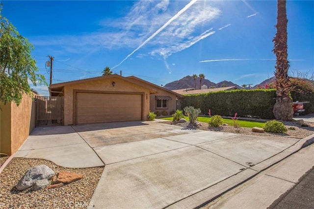 ranch-style home with a garage, concrete driveway, fence, and stucco siding