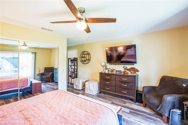 bedroom with a ceiling fan, a closet, visible vents, and wood finished floors