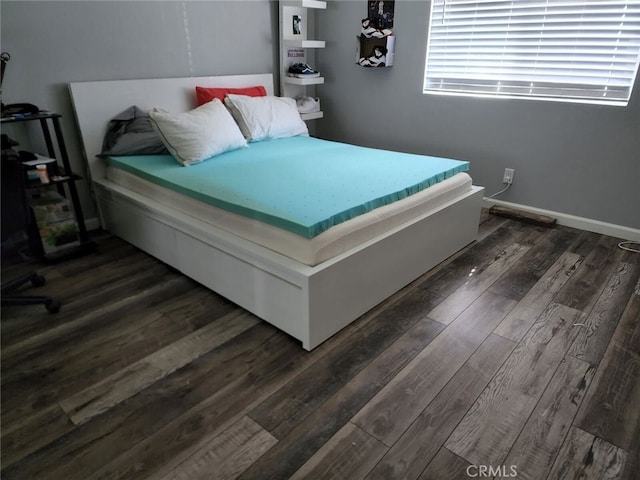 bedroom featuring dark wood-style flooring and baseboards