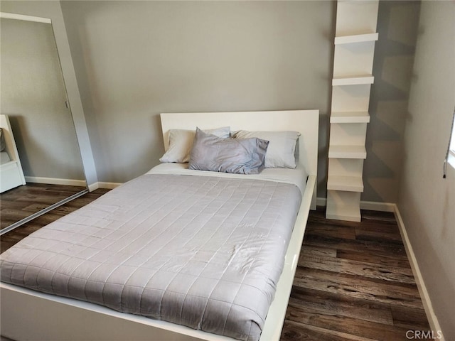 bedroom featuring baseboards and wood finished floors