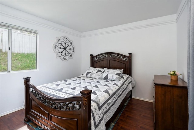 bedroom with baseboards, ornamental molding, and wood finished floors