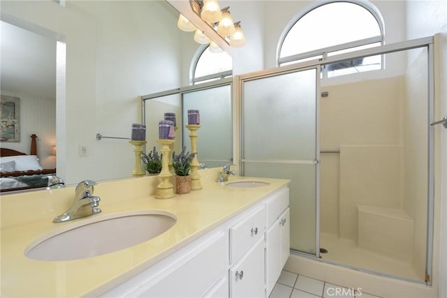 ensuite bathroom with a stall shower, double vanity, a sink, and ensuite bathroom