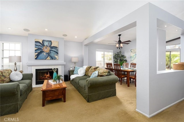 carpeted living room featuring ceiling fan, baseboards, a tiled fireplace, and recessed lighting