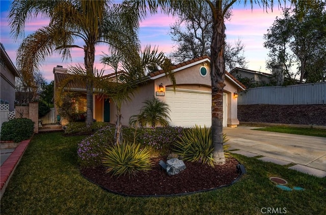 view of front of property with a garage, concrete driveway, fence, and stucco siding