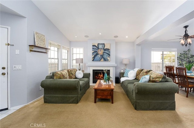 living room with a tile fireplace, light carpet, lofted ceiling, and recessed lighting