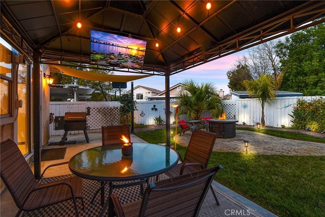 view of patio / terrace featuring a gazebo, an outdoor fire pit, fence, and outdoor dining space