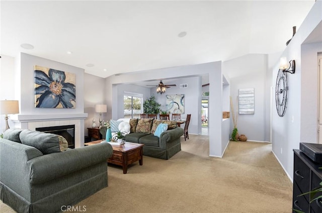 living area with light carpet, baseboards, visible vents, and a tile fireplace