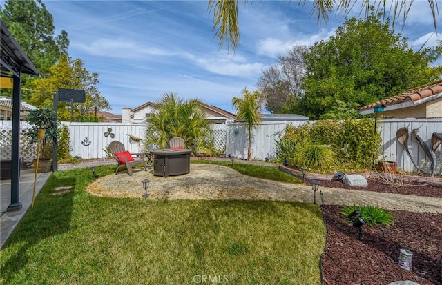 view of yard featuring a fire pit, a patio area, and a fenced backyard