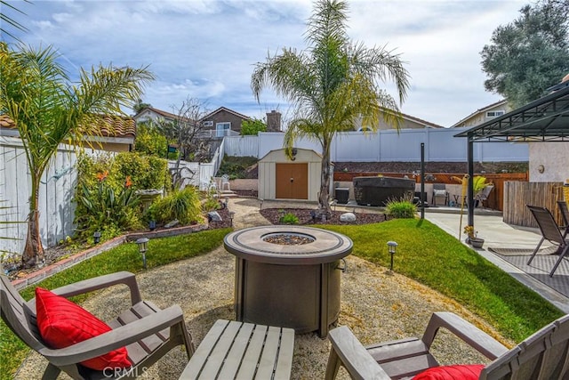 view of community featuring an outbuilding, a patio, an outdoor fire pit, a shed, and a fenced backyard