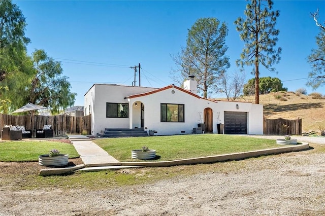 mediterranean / spanish-style home with fence, a front lawn, and stucco siding