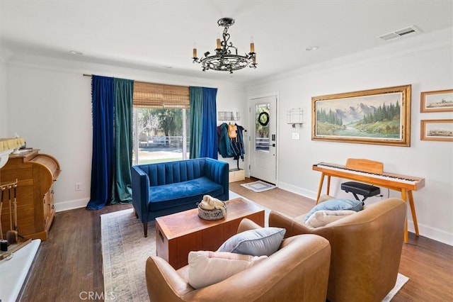 living room with an inviting chandelier, wood finished floors, visible vents, and baseboards